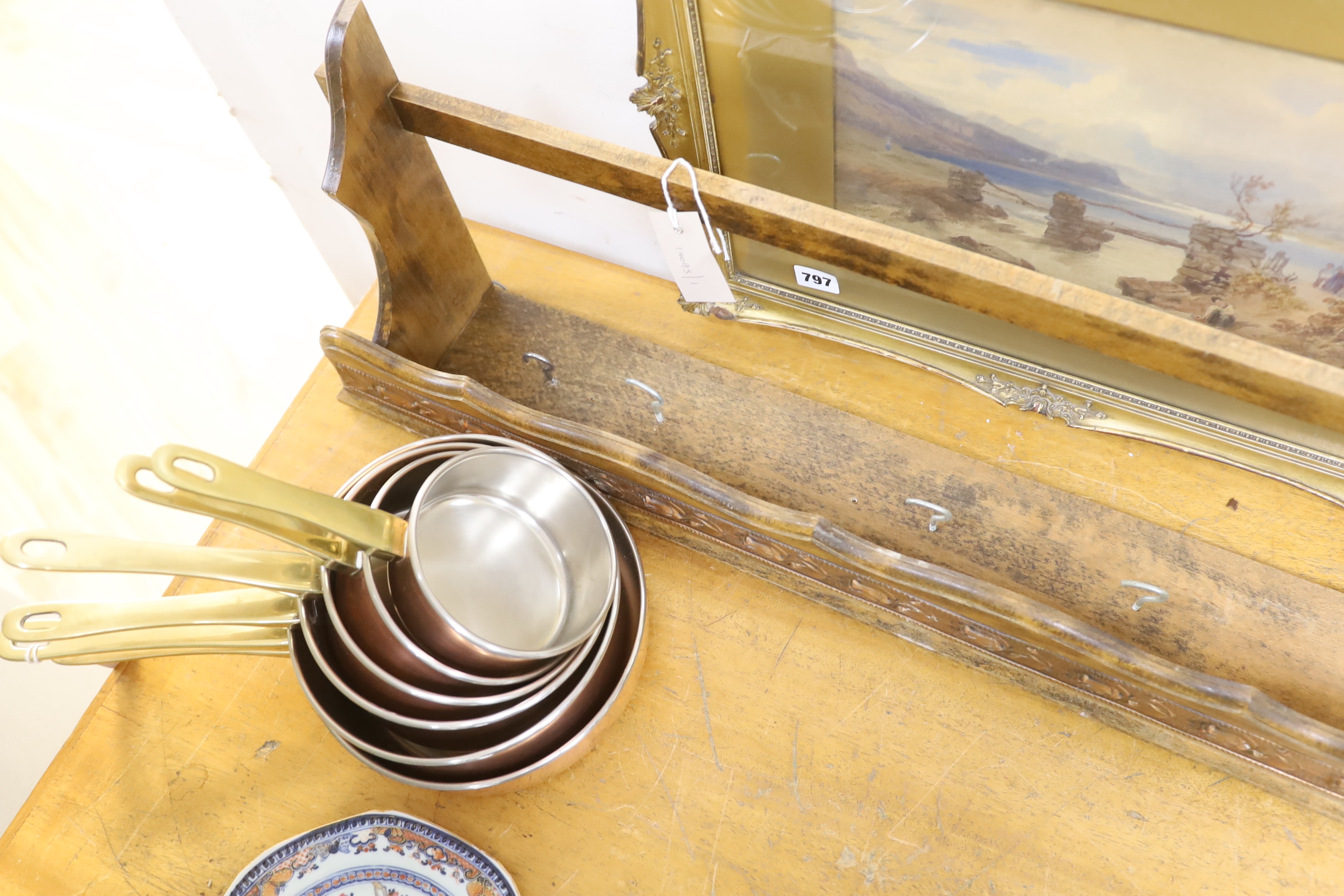 A graduated set of six copper and brass saucepans with beech hanging rack, 104cm wide